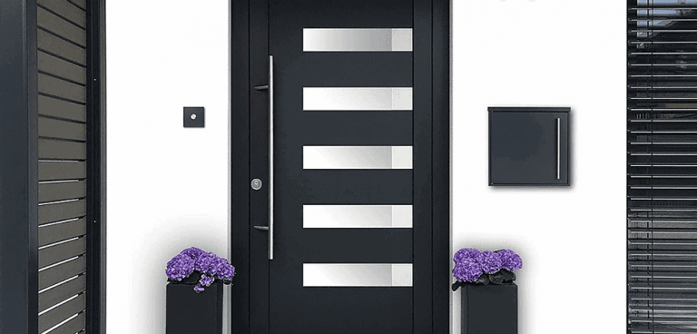 An iLoveParcels letter box mounted to a white wall next to a black foor with some purple flowers to either side